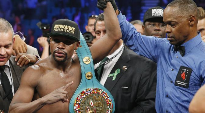 Wasit Kenny Bayless mengangkat tangan Mayweather Jr. untuk menandakan ia keluar sebagai juara megaduel lawan Pacquiao (AP Photo/John Locher)