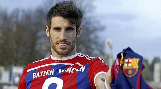 Javi Martinez menunjukkan kaus Barcelona dan Bayern Muenchen (Marca.com)
