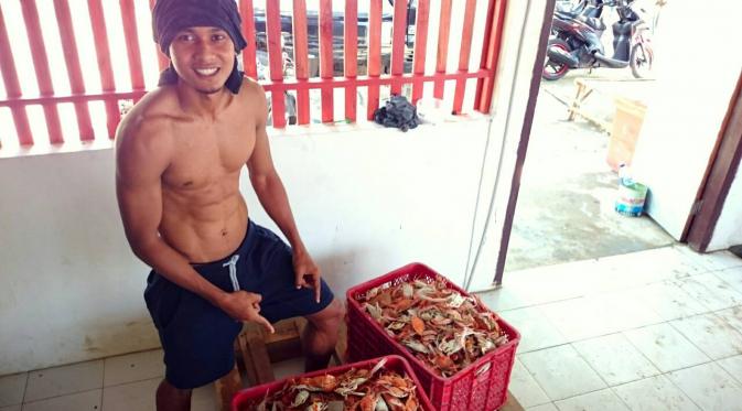 Hedro Siswanto dengan kepiting hasil tangkapan nelayan di TPI Palang, Tuban. (Bola.com/Kevin Setiawan)