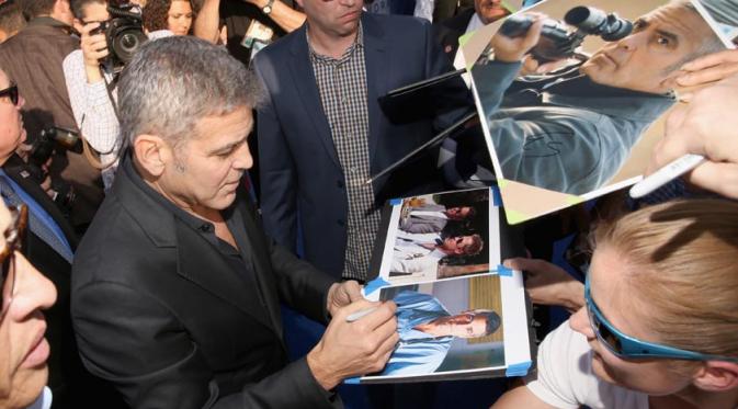 George Clooney sedang meladeni para fansnya di premier 'Tomorrowland'. Foto: via thedisneyblog.com