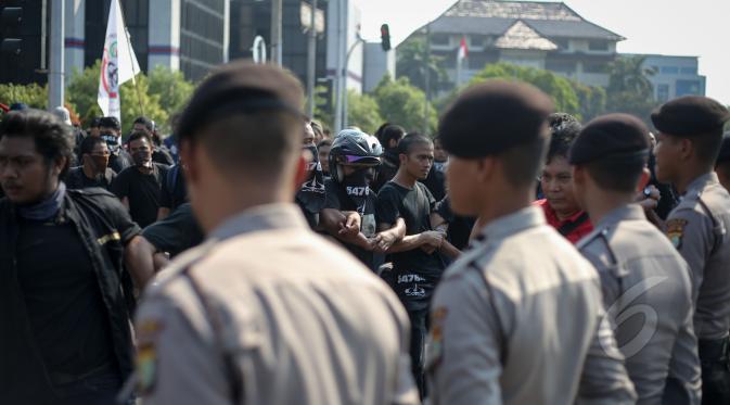 Petugas Kepolisian tampak berjaga saat aksi menolak lupa di depan Istana Merdeka, Jakarta, Selasa (12/5/2015). Mereka menuntut pemerintah untuk mengusut tuntas kasus Tragedi 12 Mei 1998 yang menewaskan 4 mahasiswa Trisakti. (Liputan6.com/Faizal Fanani)
