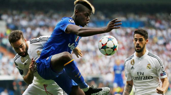 Paul Pogba (tengah) berebut bola dengan Dani Carvajal dan Isco. (Reuters / Paul Hanna)