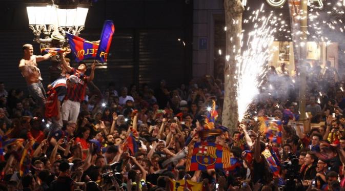 Para pendukung Barcelona merayakan kesuksesan Lionel Messi cs meraih gelar La Liga Spanyol musim ini (QUIQUE GARCIA / AFP)