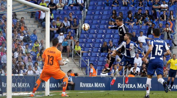 Cristiano Ronaldo (tengah) menyudul bola ke arah kiper Espanyol Kike Casilla pada laga Liga Spanyol di Stadion Power8, Senin (18/5/2015). Real Madrid menang 4-1 atas Espanyol. (Reuters/Gustau Nacarino)