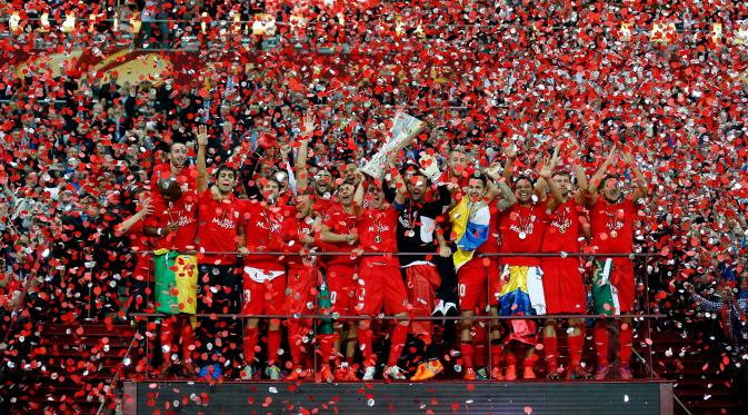 Para pemain Sevilla bergembira mengangkat trofi juara Liga Europa 2015 usai mengalahkan Dnipro di final di Stadion Narodowy, Polandia, Kamis (28/5/2015). Sevilla memecahkan rekor meraih trofi Liga Europa terbanyak, yakni empat gelar. (Reuters/Carl Recine)