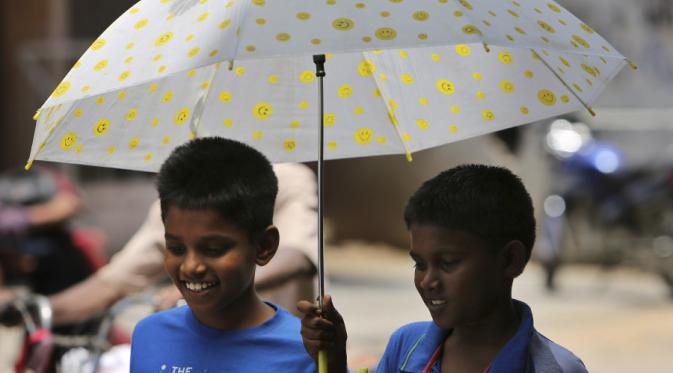 Berbagi payung bersama teman | via: AP Photo