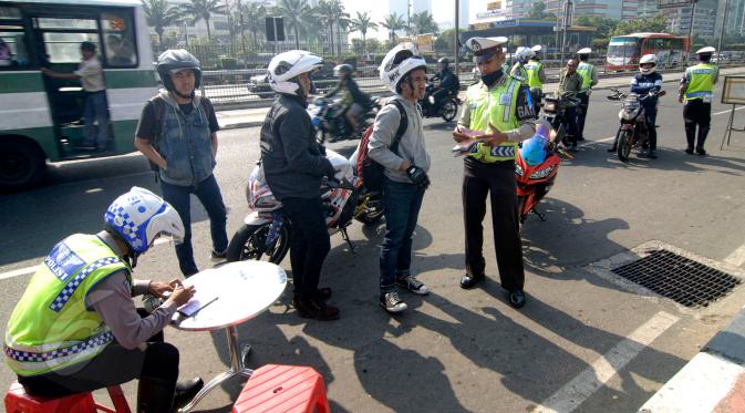 Sejumlah pengendara motor terkena tilang di sepanjang Jalan Jendral Sudirman, Jakarta, Sabtu (30/5/2015). Polisi menggelar razia patuh jaya untuk menertibkan para pengendara yang melanggar lalu lintas, mulai 27 Mei-9 Juni. (Liputan6.com/Yoppy Renato)