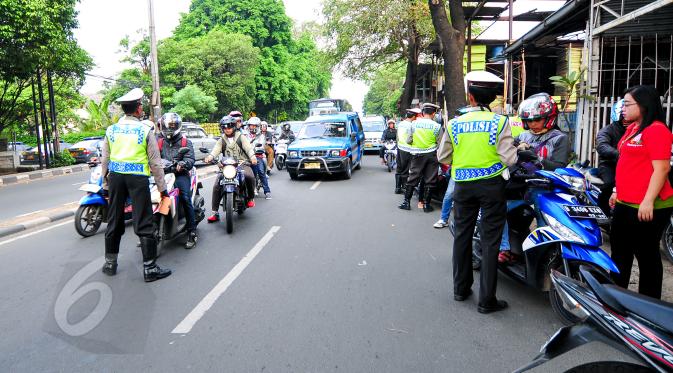 Polantas memberhentikan sejumlah kendaraan ketika Operasi Patuh Jaya di sepanjang Jalan Raya Bogor, Jakarta, Selasa(2/6/2015). Operasi tersebut untuk meningkatkan ketertiban berlalu lintas, yang dilaksanakan pada 29 Mei-9 Juni. (Liputan6.com/Yoppy Renato)