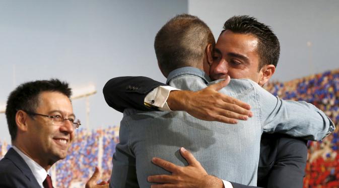 Xavi Hernandez memeluk rekan setimnya Andres Iniesta saat acara perpisahan Xavi di Auditori 1899 stadion Nou Camp, Spanyol, (3/6/2015). Xavi 673 pertandingan telah dimainkan Xavi dan mencetak 82 gol. (REUTERS/Gustau Nacarino)