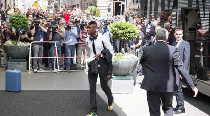 Paul Pogba tampak santai masuk ke hotel usai turun dari bus tim (Daily Mail)