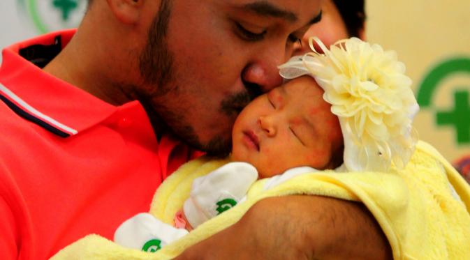 Ruben Onsu mencium anak pertamanya, RS Bunda, Jakarta, Minggu (7/6/2015). Ruben memberi nama anak pertamanya Thalia Putri Onsu (Liputan6.com/Faisal R Syam)