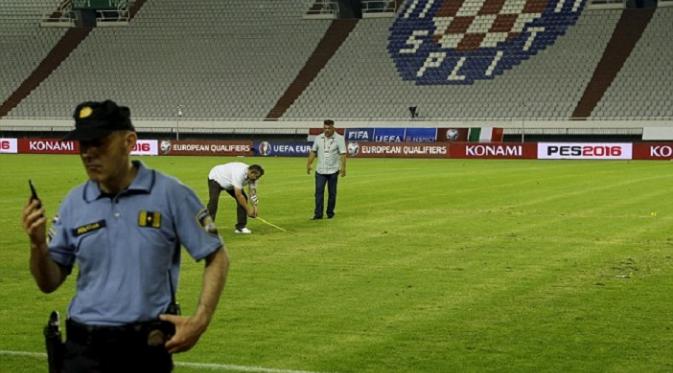 Petugas stadion berusaha menghilangkan simbol Nazi saat jeda babak pertama