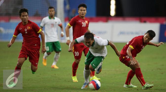 Pemain timnas Indonesia U-23, Wawan Pebriyanto (kedua kanan) berusaha menembus pertahanan Vietnam di laga perebutan tempat ketiga Sepak Bola SEA Games 2015 di National Stadium Singapura (15/6/2015). Indonesia kalah 0-5. (Liputan6.com/Helmi Fithriansyah)