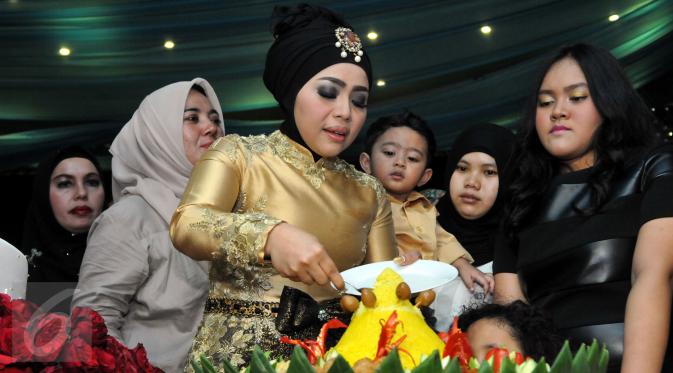 Istri Nassar, Muzdalifah memotong tumpeng pada perayaan ulang tahunnya yang ke-37 tahun di kawasan Pramuka, Jakarta Timur, Senin (15/6/2015). (Liputan6.com/Panji Diksana)