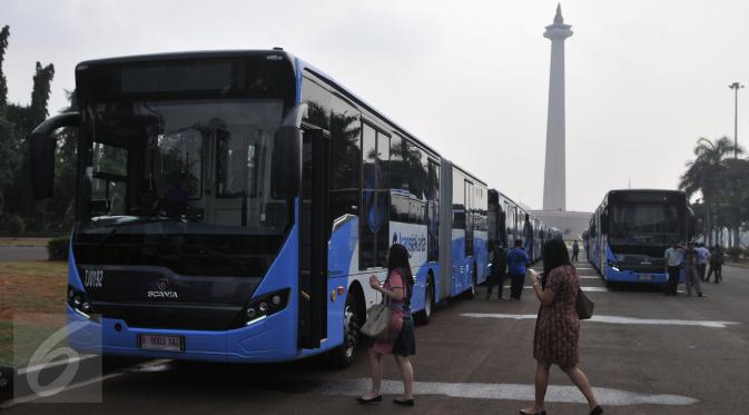 Pengunjung saat akan menaiki Bus transjakarta bermerek Scania di Silang Monas, Jakarta, Senin (22/6/2015). Sebanyak 20 unit bus transjakarta bermerek Scania yang diluncurkan  tepat di HUT ke-488 DKI Jakarta. (Liputan6.com/Herman Zakharia) 