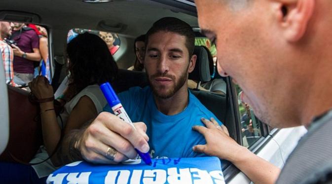 Dalam perjalannya, Ramos masih sempat bubuhkan tanda tangan untuk fans. | via: Getty Images