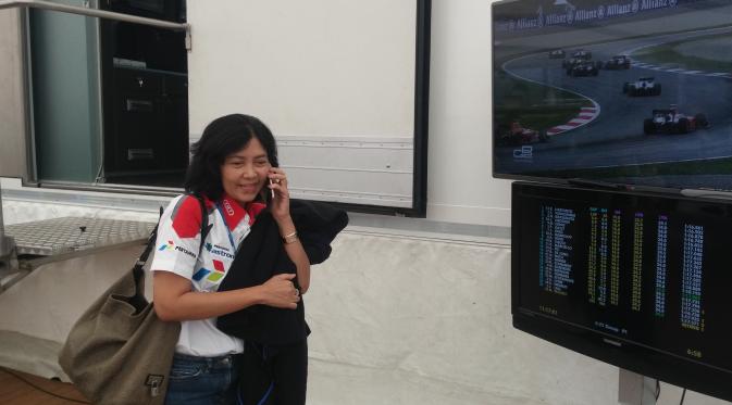Indah Pennywati memberikan kabar kepada suaminya beberapa saat setelah Rio finis di posisi pertama sprint race GP2 Austria. (Bola.com/Reza Khomaini)
