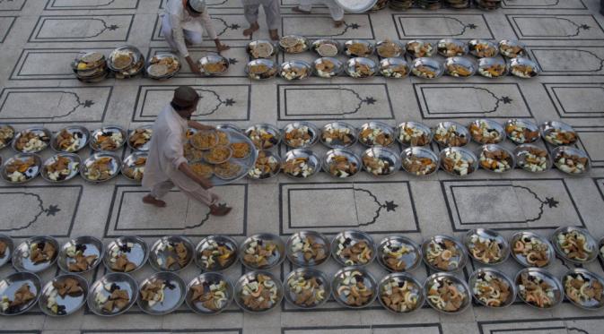 Relawan Pakistan mengatur makanan untuk berbuka puasa di sebuah masjid lokal selama Ramadhan di Karachi, Pakistan