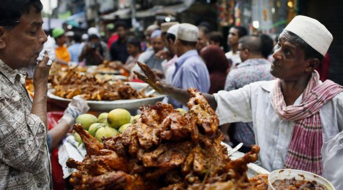 Sebuah vendor Bangladesh, tepat, menjual makanan untuk berbuka, makan malam untuk berbuka puasa setiap hari di daerah pasar pada hari pertama Ramadan di Dhaka, Bangladesh,