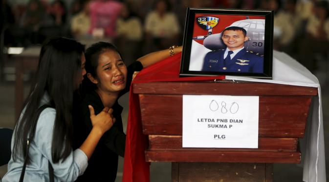 Seorang wanita menangis di samping peti mati suaminya yang menjadi korban dari jatuhnya pesawat Hercules C-130 di Medan, Rabu (1/7/2015). Peristiwa ini menambah catatan kecelakaan yang disebabkan tuanya alustista yang digunakan TNI. (REUTERS/Beawiharta)