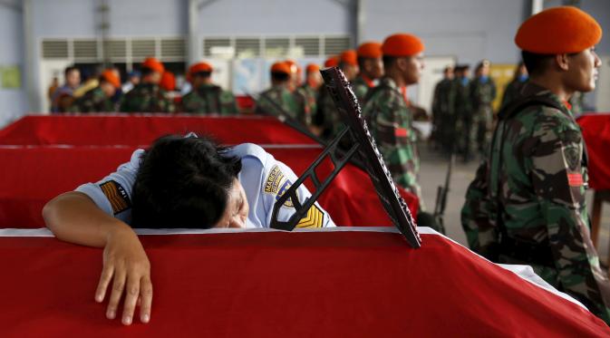 Seorang anggota Wara memeluk peti mati suaminya yang menjadi korban dari jatuhnya pesawat Hercules C-130 di Medan, Rabu (1/7/2015). Peristiwa ini menambah catatan kecelakaan yang disebabkan tuanya alustista yang digunakan TNI. (REUTERS/Beawiharta)