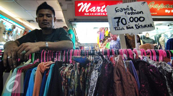 Seorang penjual tampak bergaya di dekat barang dagangannya di Pasar Tanah Abang, Jakarta, Kamis (2/7/2015). Memasuki pertengahan Ramadan pedagang mengaku penjualan baju muslim meningkat dari bulan-bulan sebelumnya. (Liputan6.com/Yoppy Renato)