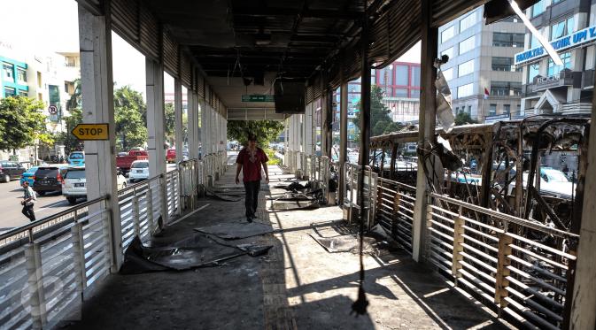 Warga berjalan di halte UI Salemba yang ikut terbakar bersama dengan Bus gandeng Transjakarta koridor V Ancol - Kampung Melayu pagi tadi, Jakarta, Jumat (7/3/2015). Akibat kebakaran tersebut, Halte UI Salemba rusak ringan. (Liputan6.com/Faizal Fanani)