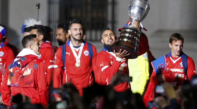 Arturo Vidal dan rekan-rekannya dengan trofi Copa America menyambut suporter Cile dari balkon Istana Presiden. (REUTERS/Carlos Garcia Rawlins)