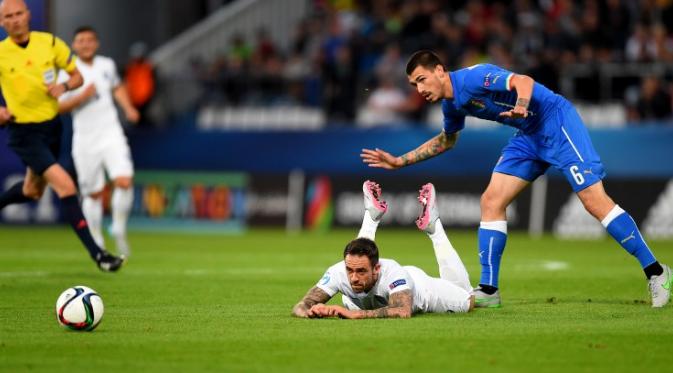 England's Danny Ings (laying on the pitch) and Italy's Alessio Romagnoli (R) watch a ball during the UEFA Under21 European Championship 2015/ AFP PHOTO / JOE KLAMAR 
