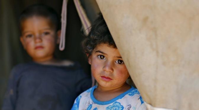Ekspresi seorang anak pengungsi Suriah yang telah tinggal di Yordania dengan keluarga mereka selama 2,5 tahun di kota Madaba, Kamis (9/7/2015). Jumlah pengungsi Suriah di negara-negara tetangga telah melewati 4 juta penduduk. (REUTERS/Muhammad Hamed)