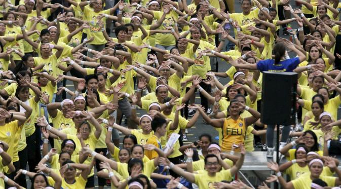 Seorang instruktur memimpin gerakan saat kelas zumba terbesar yang diadakan di sepanjang jalan utama Manila, Filipina, Minggu (19/7/2015). Warga Filipina memecahkan rekor Guinness World Records dengan peserta mencapai 12, 975. (REUTERS/Lorgina Minguito)