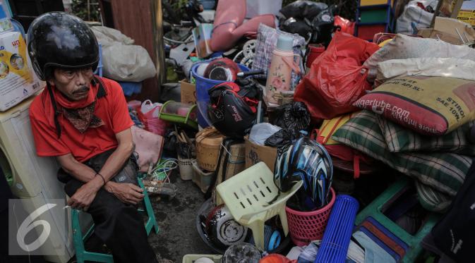 Seorang warga termenung di antara tumpukan barang usai penggusuran di Rawasari Selatan, Jakarta, Kamis (23/7/2015). Pemprov DKI mengambil alih lahan seluas 1.300 meter persegi yang selama lima tahun dikuasai pihak swasta. (Liputan6.com/Faizal Fanani)