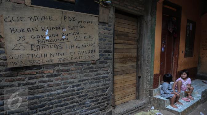 Tulisan protes terhadap penggusuran ditulis di tembok rumah warga di kawasan pemukiman Kampung Pulo, Jakarta Timur, Kamis (23/7). Pemerintah Provinsi DKI Jakarta akan menertibkan bangunan liar yang ada di wilayah Kampung Pulo. (Liputan6.com/Faizal Fanani)