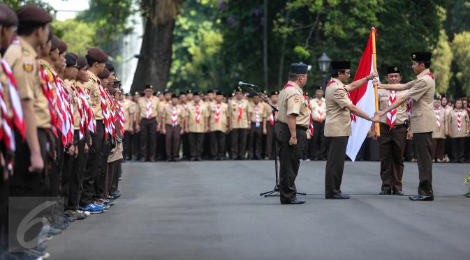 Presiden Jokowi (kanan) menyerahkan bendera merah putih kepada Ketua Kwarnas Gerakan Pramuka Adhyaksa Dault saat pelepasan 462 kontingen Pramuka Indonesia yang akan mengikuti Jambore Pramuka Dunia ke-23, Jakarta, Jumat (24/7). (/Faizal Fanani)