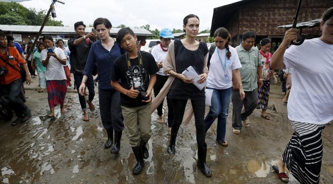 Utusan khusus UNHCR, Angelina Jolie bersama putranya, Maddox saat mengunjungi kamp pengungsian etnis Kachin di Jam Mai Kaung IDP, Myitkyina, Myanmar, Rabu (30/7/2015). (REUTERS/Soe Zeya Tun)