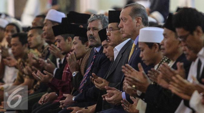Wakil Presiden Jusuf Kalla dan Presiden Turki Reccep Tayyip Erdogan berdoa usai shalat Jumat di Mesjid Istiqlal, Jakarta, Jumat (31/7/2015). Erdogan berada di Indonesia selama tiga hari dalam rangka kunjungan kenegaraan. (Liputan6.com/Faizal Fanani)