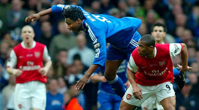 Gelandang Chelsea, John Obi Mikel terjatuh saat berebut bola dengan gelandang Arsenal, Julio Baptista pada babak final Carling Cup di Millenium Stadium, Wales, Minggu (25/2/2007). (EPA/Gerry Penny)