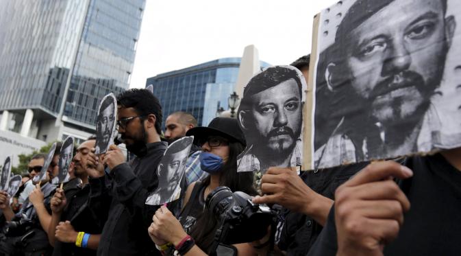 Sejumlah Wartawan  dan aktivis membawa foto Ruben Espinosa  saat menggelar protes di monumen Kemerdekaan,  Meksiko, Minggu (2/8/2015).  Espinosa ditemukan tewas setelah melarikan diri dari tekanan di negara Veracruz. (REUTERS/Henry Romero)