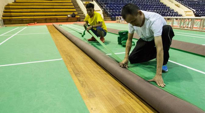 Pekerja memasang karpet lapangan jelang Kejuaraan Dunia BWF di Istora Senayan, Jakarta, Rabu (5/8/2015). Tahun ini merupakan kesempatan ketiga Indonesia menjadi tuan rumah setelah tahun 1980 dan 1989. (Bola.com/Vitalis Yogi Trisna)