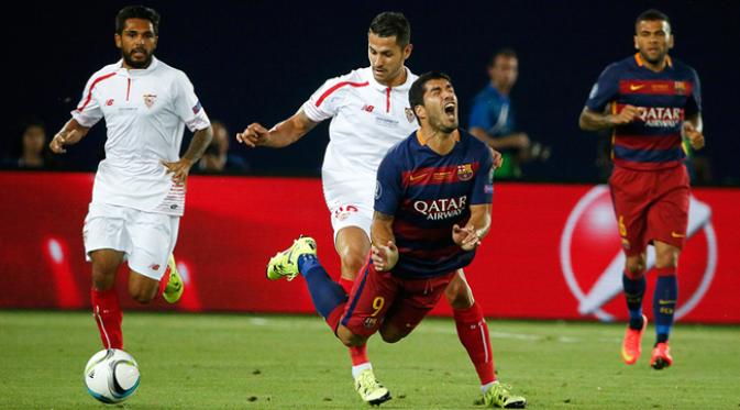 Pemain Barcelona, Luis Suarez terjatuh akibat didorong pemain Sevilla, Vitolo pada laga UEFA Super Cup di Tbilisi, Georgia, Selasa (11/8/2015). Bercelona menang 5-4 atas Sevilla. (Reuters/Grigory Dukor)