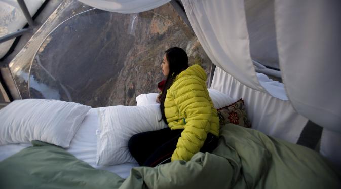 Seorang tamu menikmati pemandangan dari dalam kapsul tidur di Skylodge Adventure Suites di Lembah Suci di Cuzco, Peru, 14 Agustus 2015. Hotel tergantung dengan ketinggian 400 meter ini memiliki tarif sekitar Rp 4 juta per malam. (REUTERS/Pilar Olivares)