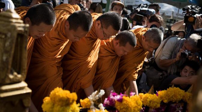 Sejumlah biksu memimpin doa untuk pembukaan kembali Kuil Erawan yang sempat ditutup karena peristiwa ledakan bom pada Senin (17/8), Bangkok, Rabu (19/8/2015). Peristiwa tersebut dikabarkan telah menewaskan sekitar 20 orang. (AFP Photo/Jerome Taylor)