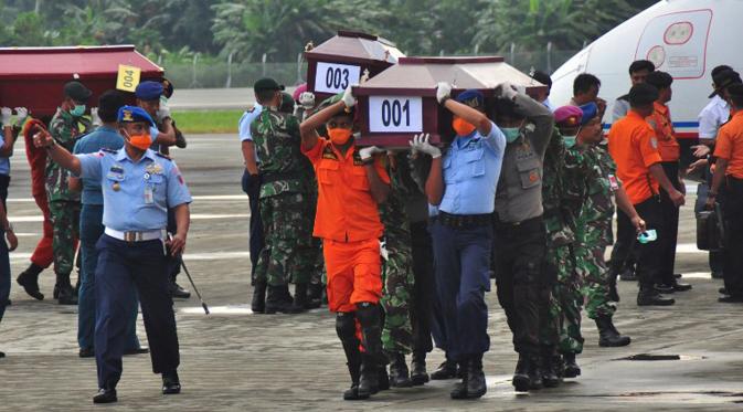 Sejumlah petugas mengangkat peti jenazah korban kecelakaan Trigana Air di Bandara Sentani, Kabupaten Jayapura, Papua, Rabu (19/8). Lima awak dan 49 penumpang menjadi korban kecelakaan pesawat pada 16 Agustus 2015 lalu. (AFP PHOTO/Indrayadi Thamrin)