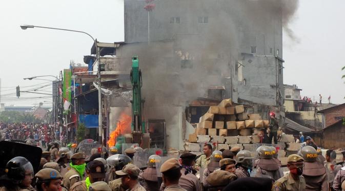 Warga Kampung Pulo menolak direlokasi. Mereka pun membakar alat berat Ekskavator. (Nafiysul Qodar/Liputan6.com)