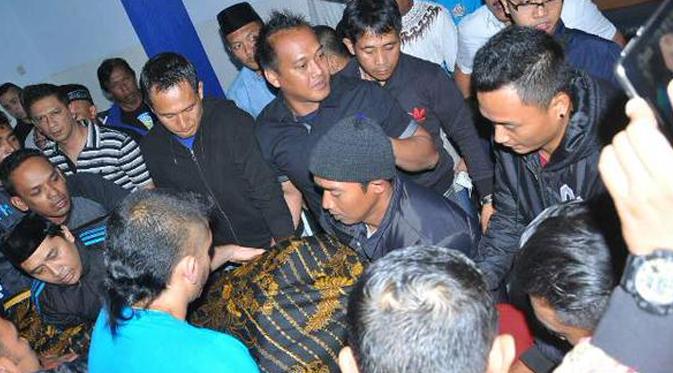 Kiper Arema, Ahmad Kurniawan membantu mengangkat jenazah Suharno ke rumah terakhirnya.