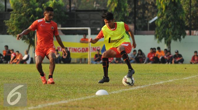 Pesepakbola Persija, Ramdani Lestaluhu (kiri) menghalangi pergerakan rekan setimnya saat latihan di Markas Yon Zikon 14, Jakarta, Senin (24/8/2015). Persija kembali berlatih untuk menghadapi turnamen Piala Presiden 2015. (Liputan6.com/Helmi Fithriansyah)