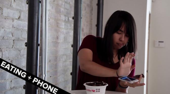 Makan sambil jawab handphone. (Via: youtube.com)