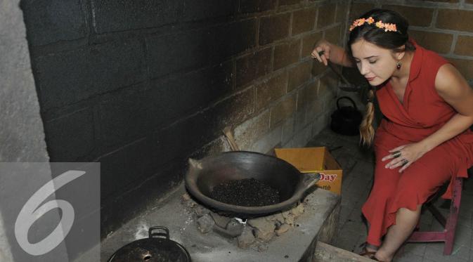 Pemeran Melek di serial Elif, Selin Sezgin mencoba memasak biji kopi luwak di Bali. [Foto: Herman Zakaria/Liputan6.com]