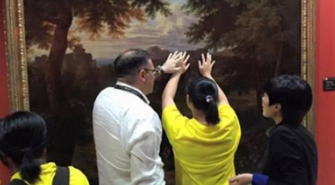 Kurator Andrea Rossie membantu anak dengan penglihatan terbatas meraba lukisan tanpa sarung tangan. Menimbulkan banyak pertanyaan tentang keasilannya (SCMP)