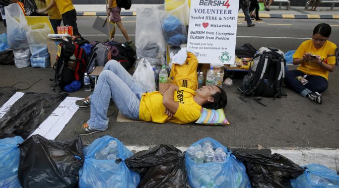 Seorang pengunjuk rasa tertidur diantara kantong plastik saat aksi gerakan Bersih 4.0 di ibukota Malaysia, Kuala Lumpur, Minggu (30/8/2015). Aksi tersebut menuntut pengunduran diri PM Malaysia Najib Razak terkait tuduhan korupsi. (REUTERS/Olivia Harris)